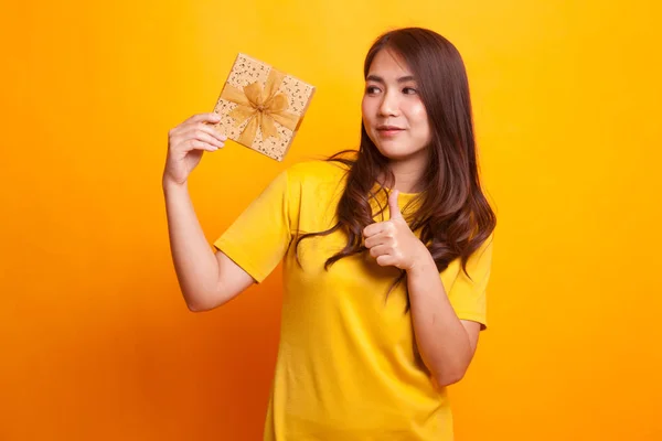 Joven mujer asiática pulgares arriba con una caja de regalo . — Foto de Stock