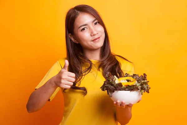 健康的亚洲妇女大拇指与沙拉在黄色礼服 — 图库照片