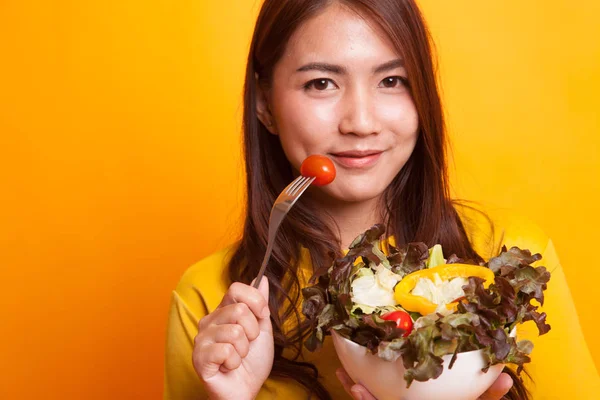 Gezonde Aziatische vrouw met salade in gele jurk — Stockfoto