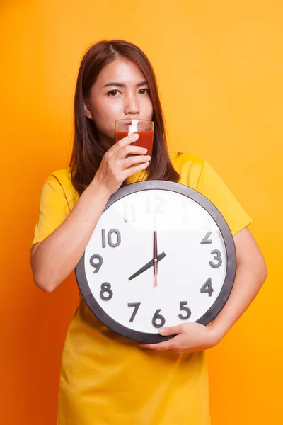 Jovem mulher asiática com suco de tomate e relógio em vestido amarelo — Fotografia de Stock