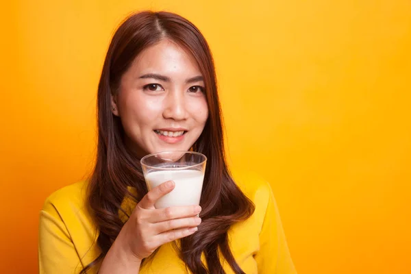 Gesunde asiatische Frau trinkt ein Glas Milch im gelben Kleid — Stockfoto