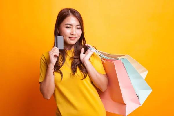 ショッピング バッグと黄色のドレスに空白カードを持つ若いアジア女性 — ストック写真