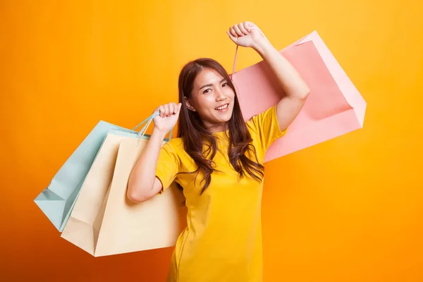 Jonge Aziatische vrouw tevreden boodschappentas in gele jurk — Stockfoto