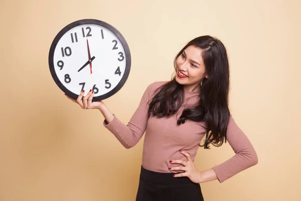 Young Asian woman with a clock. — Stock Photo, Image