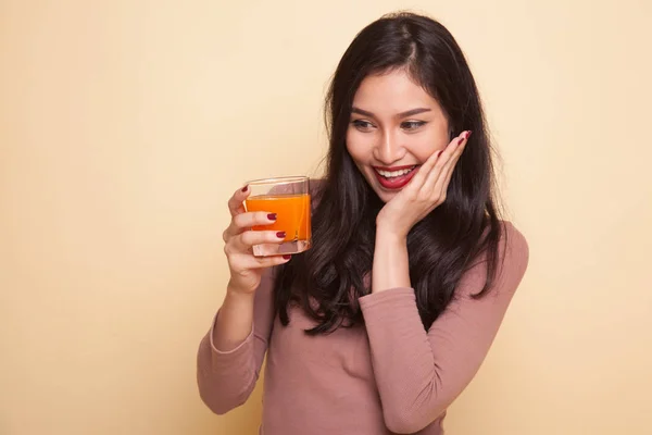 Jovem mulher asiática polegares até beber suco de laranja . — Fotografia de Stock