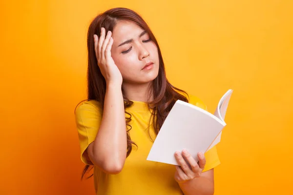Νεαρά ασιατικές γυναίκα έχεις πονοκέφαλο Διαβάστε ένα βιβλίο. — Φωτογραφία Αρχείου