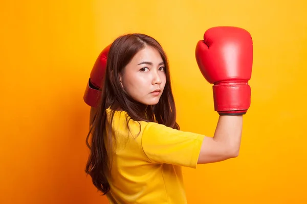 Mujer asiática joven con guantes de boxeo rojos en vestido amarillo —  Fotos de Stock