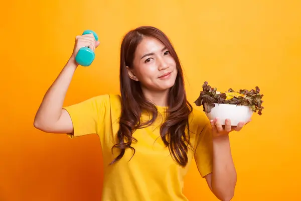 Gezonde Aziatische vrouw met halters en salade in gele jurk — Stockfoto