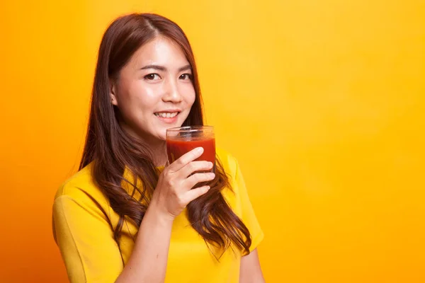 Jovem mulher asiática beber suco de tomate em vestido amarelo — Fotografia de Stock