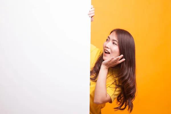 Excited young Asian woman with blank sign in yellow dress — Stock Photo, Image