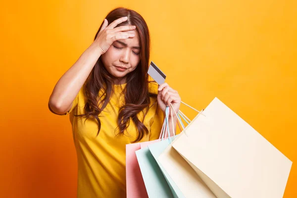 Ongelukkige jonge Aziatische vrouw met boodschappentassen en credit card in — Stockfoto