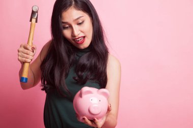 Asyalı kadın domuz para banka ve çekiç ile.