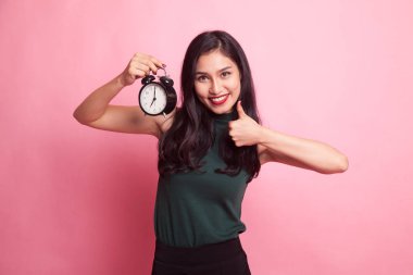 Genç Asyalı kadın ortaya başparmak ile bir saat.