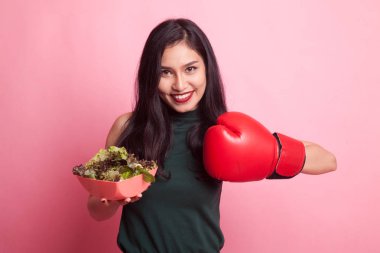 Genç Asyalı kadın boks eldiven ve salata ile.