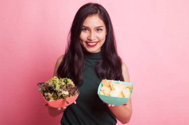 Patates kızartması ve salata ile genç Asyalı kadın.