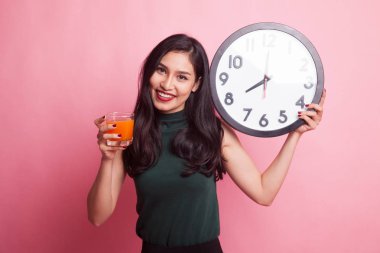 Asyalı kadın saati içki portakal suyu ile.