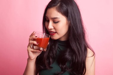 Genç Asyalı kadın içki domates suyu.