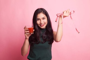 Domates suyu ve ölçüm bandı ile Asyalı kadın.