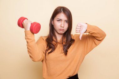Dumbbells ile mutsuz Asyalı kadın başparmak aşağı.
