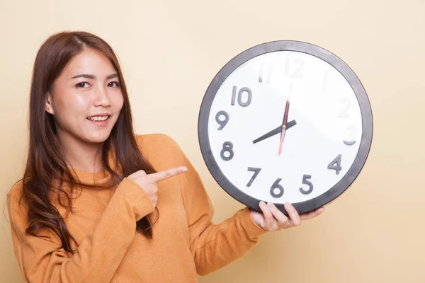 Wanita Asia muda menunjuk ke sebuah jam . — Stok Foto