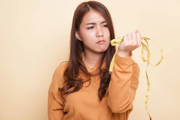 Unhappy young Asian woman with measuring tape. — Stock Photo, Image