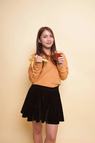 Asiatisk kvinna med tomatjuice och måttband. — Stockfoto