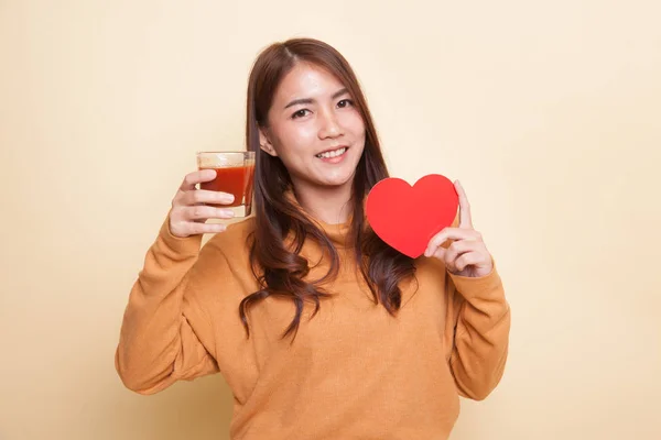 Młoda kobieta azjatyckich z pomidorów sok i czerwone serce. — Zdjęcie stockowe