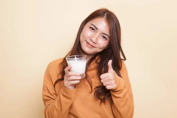 Friska asiatisk kvinna dricka ett glas mjölk tummen. — Stockfoto