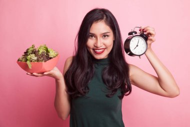 Saat ve salata ile genç Asyalı kadın.
