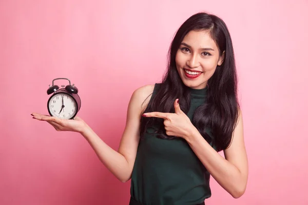 Joven asiática mujer punto a un reloj . —  Fotos de Stock