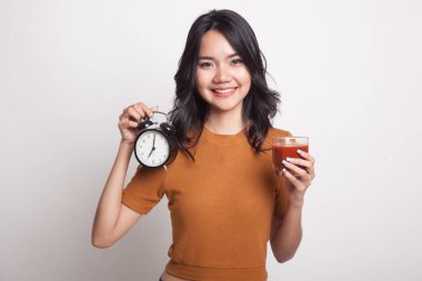 Domates suyu ve saat ile genç Asyalı kadın.