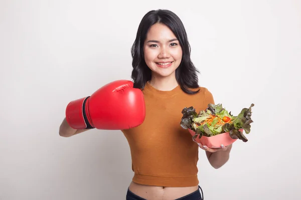 Jonge Aziatische vrouw met bokshandschoen en salade. — Stockfoto