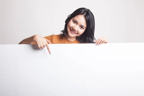 Jonge Aziatische vrouw punt naar een leeg teken. — Stockfoto
