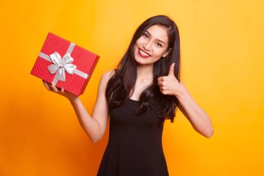 Genç Asyalı kadın göstermek zafer işareti ile bir hediye kutusu.