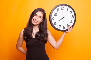 Saati olan genç Asyalı kadın..