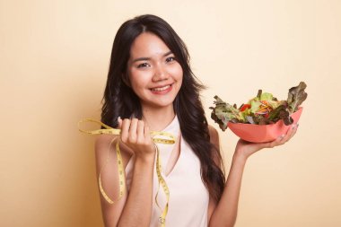 Ölçme bant ve salata ile mutsuz Asyalı kadın.