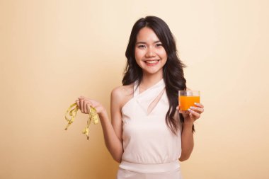 Asyalı kadın içki portakal suyu tutun teyp ölçme.