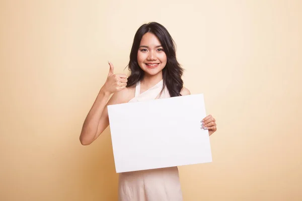 Junge asiatische Frau zeigen Daumen nach oben mit weißen leeren Zeichen. — Stockfoto