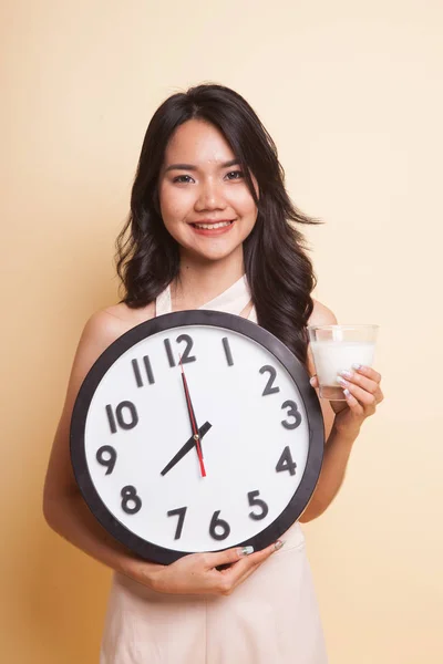 Femme asiatique en bonne santé boire verre de lait tenir horloge . — Photo