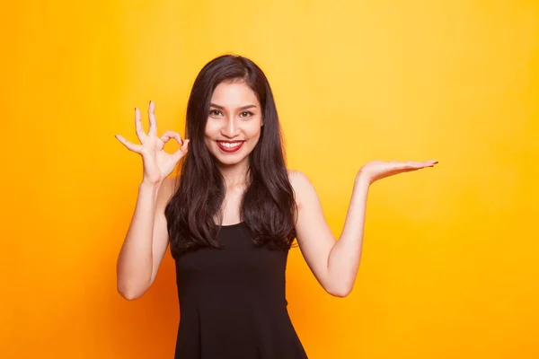 Beautiful young Asian woman show palm hand and OK sign. — Stock Photo, Image