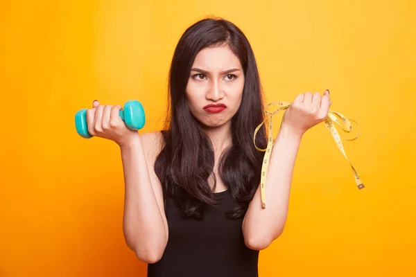 Ongelukkige jonge Aziatische vrouw met meetlint. — Stockfoto