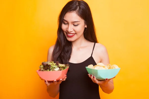 Giovane donna asiatica con patatine e insalata . — Foto Stock