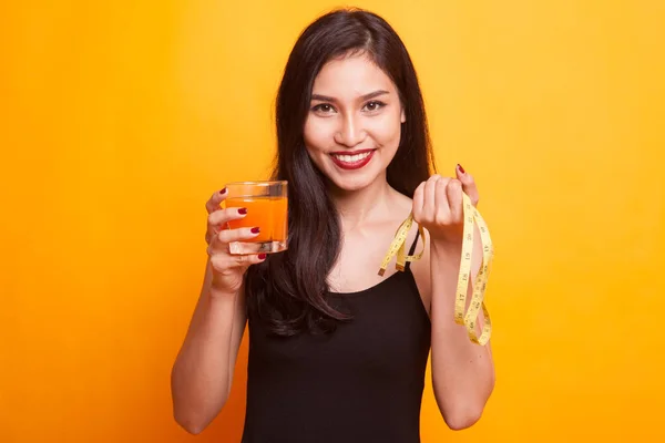Jovem mulher asiática com haltere beber suco de laranja . — Fotografia de Stock