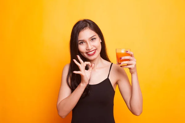 Asian woman with a clock drink orange juice. — Stock Photo, Image