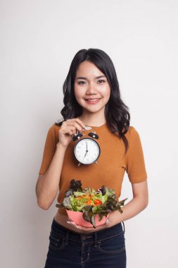 Saat ve salata ile genç Asyalı kadın.