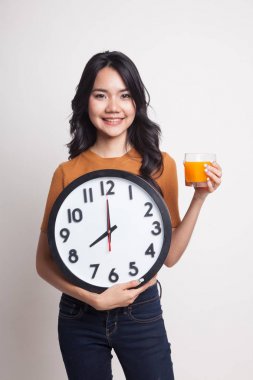 Asyalı kadın saati içki portakal suyu ile.