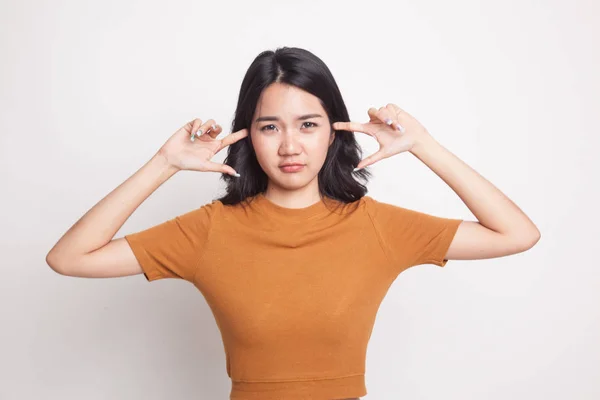 Junge asiatische Frau blockiert beide Ohren mit Fingern. — Stockfoto