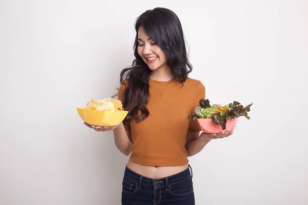 Ung asiatisk kvinna med potatischips och sallad. — Stockfoto