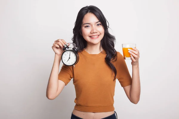 Femme asiatique avec une horloge boisson jus d'orange . — Photo