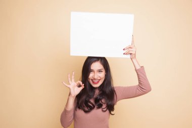Genç Asyalı kadın göster Tamam beyaz boş işaretiyle.